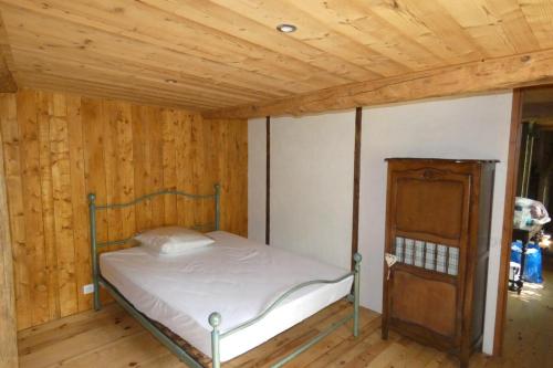 une chambre avec un lit et un plafond en bois dans l'établissement Chalet de Saint Dalmas, à Saint-Dalmas-le-Selvage