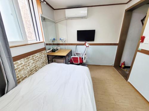 a bedroom with a bed and a desk and a tv at Sweet House in Seoul