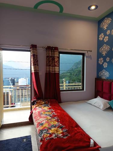 a bedroom with a bed and a large window at Shiva home stay in Ukhimath