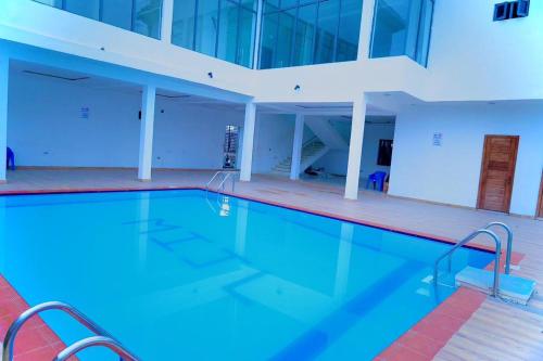 a large swimming pool with blue water in a building at Stay Well Homes Comfortinn in Lekki