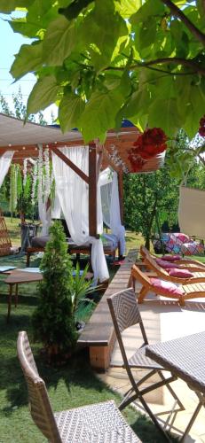 a gazebo with chairs and tables in a yard at Smestaj sa bazenom Sunny Hill in Smederevska Palanka