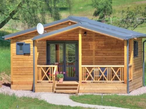 a wooden cabin with a porch and a door at Chalet Jonquille avec Spa dans les Vosges du Sud - FR-1-583-500 in La Vaivre