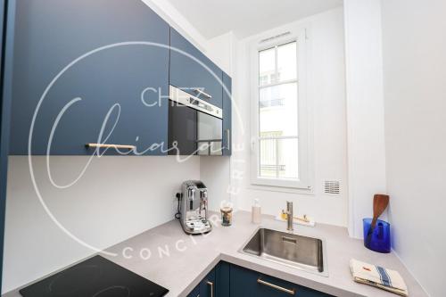 une cuisine avec un évier et un micro-ondes dans l'établissement EIFFEL TOWER Charming and Modern Flat, à Paris