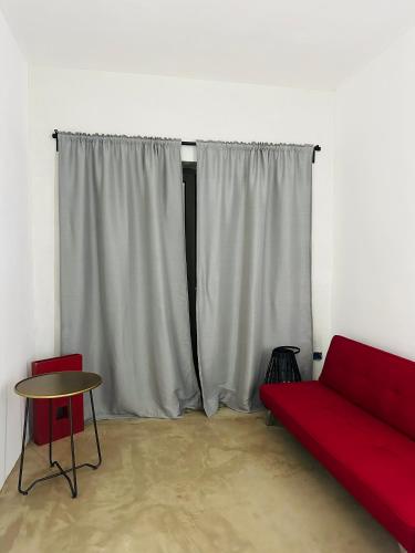 a living room with a red couch and a table at L'Armino in Otranto