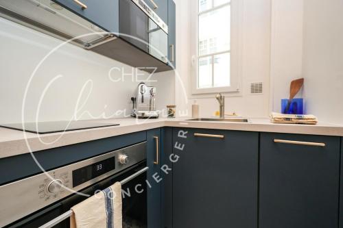 une cuisine avec des armoires bleues et un évier dans l'établissement EIFFEL TOWER Charming and Modern Flat, à Paris