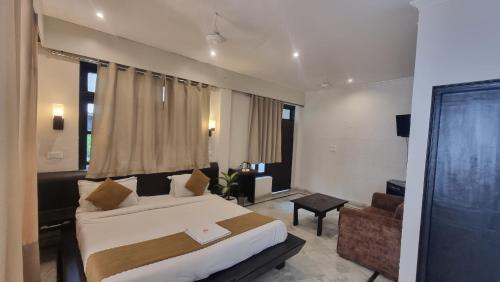 a bedroom with a large bed and a living room at Oslo Ganges by Around stays, Tapovan in Rishīkesh