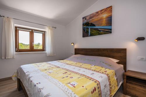 a bedroom with a bed with a yellow comforter at Villa Azi, a cozy mediterranean hideaway, peaceful and fenced in Pićan