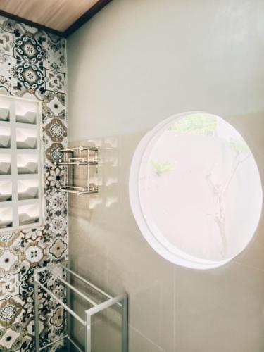 a bathroom with a round window on the wall at Firdaus Studio Apartments in Dalung