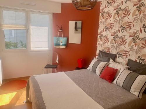 - une chambre avec un lit aux murs orange dans l'établissement Grand appartement les pieds dans l'eau, à La Baule