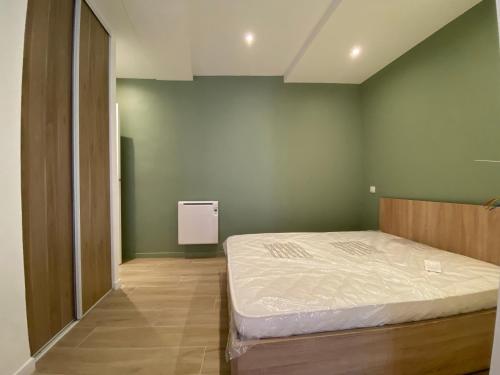 une chambre avec un lit et un mur végétal dans l'établissement Superbe studio avec coin nuit vieux nice !, à Nice