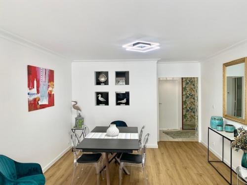 un salon avec une table et une salle à manger dans l'établissement Grand appartement les pieds dans l'eau, à La Baule