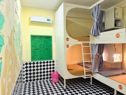a room with bunk beds with a checkerboard floor at Vang Vieng Golden Dragon House in Vang Vieng