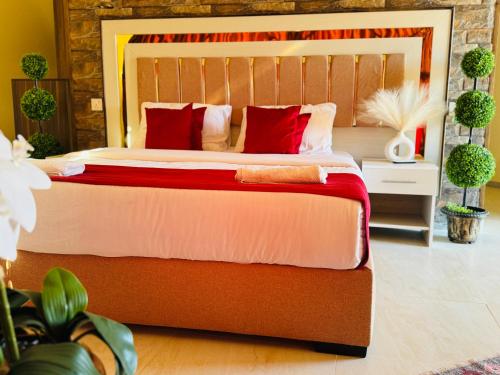 a bedroom with a large bed with red pillows at Wadi Rum Legend Luxury Camp in Wadi Rum