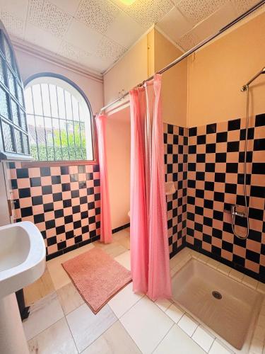 La salle de bains est pourvue d'un rideau de douche rose et d'un lavabo. dans l'établissement Studio sud à 300m des plages, à Mimizan