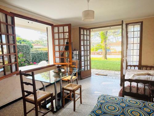 un salon avec une table en verre et une chambre dans l'établissement Studio sud à 300m des plages, à Mimizan