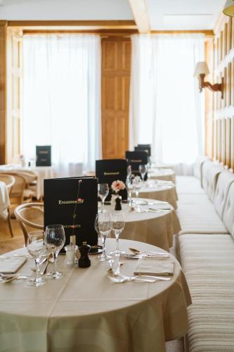 a row of tables in a restaurant with wine glasses at Boutique Hotel Engadinerhof - A Home for Generations in Pontresina