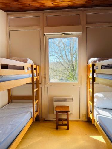 une chambre avec trois lits superposés et une fenêtre dans l'établissement Appartement 6 pers vue jardin, à La Salvetat-sur-Agout