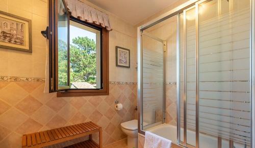 a bathroom with a shower and a toilet and a window at FINCA LA GRANDA DE LA CONCHA in Nueva de Llanes