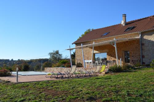 un groupe de bancs devant un bâtiment dans l'établissement La maison du Romarin, à Meyssac