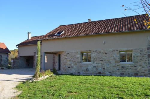 une maison en pierre avec un arbre dans la cour dans l'établissement La maison du Romarin, à Meyssac