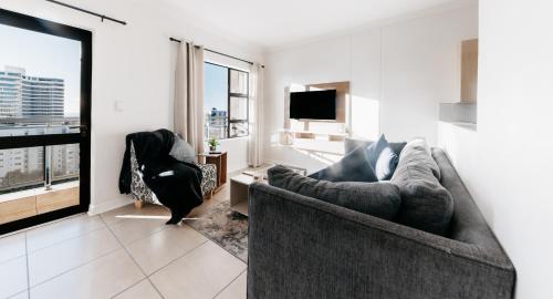 a living room with a couch and a tv at Opulent Heights- Westpoint Sandton in Johannesburg