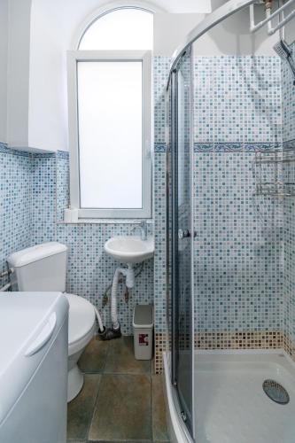 a bathroom with a shower and a toilet and a sink at Дім з двориком, центр, море in Odesa