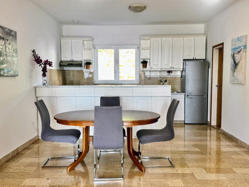 a kitchen with a table and chairs and a refrigerator at Indigo Cavtat Apartments in Cavtat