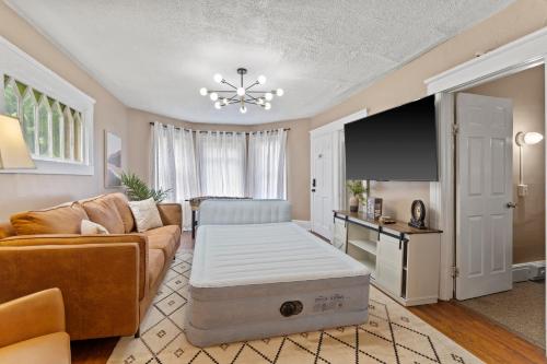 a living room with a couch and a flat screen tv at Modern 6BR Near Syracuse U, Destiny & Zoo Sleeps 18 in Syracuse