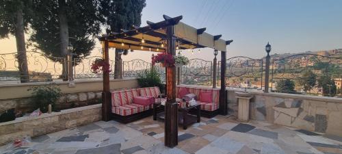 a gazebo with pink chairs and a table at Maison des Couleurs in Aley