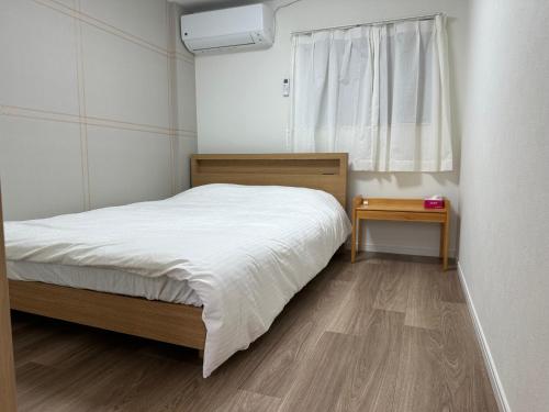 a small bedroom with a bed and a window at 寬居 kuanju 一棟貸し 広々一戸建て JR桜ノ宮駅徒歩3分 最大8名 梅田 大阪城公園アクセス良好 in Osaka