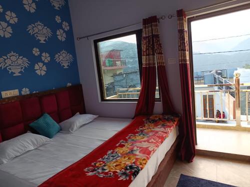 a bed in a room with a large window at Shiva home stay in Ukhimath