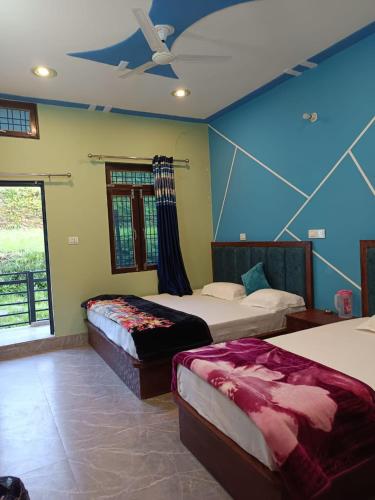 a bedroom with two beds and a ceiling fan at Shiva home stay in Ukhimath
