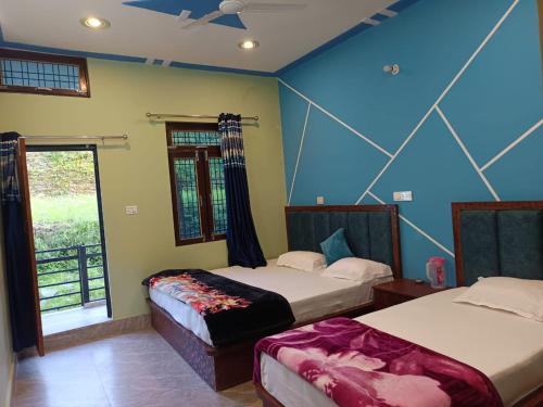 two beds in a room with blue walls and a window at Shiva home stay in Ukhimath