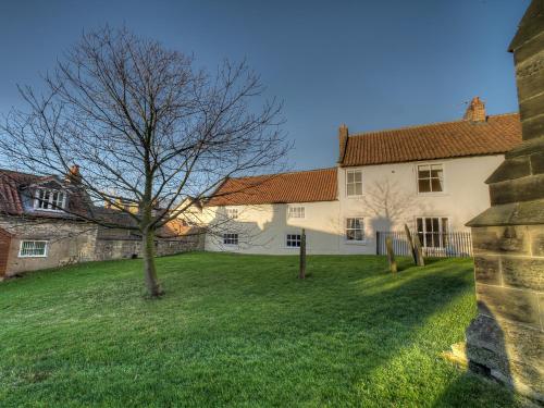 a tree in the yard of a house at Kings Head Cottage in Pickering