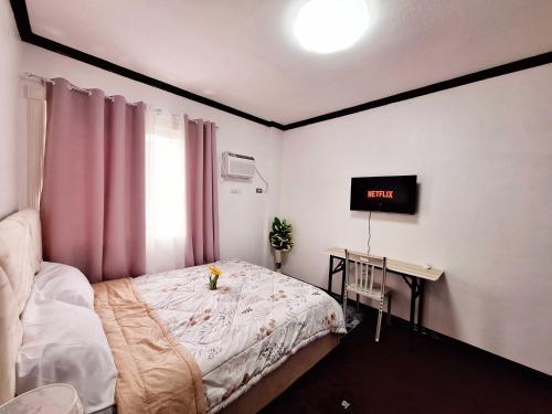 une petite chambre avec un lit et un bureau dans l'établissement EA3 Affordable Apartment Room Transient House Near SM Ecoland, Davao Coastal Road and Ecoland Bus Terminal, à Davao
