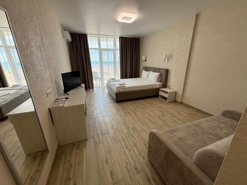 a large hotel room with a bed and a television at Milos Hotel in Zatoka