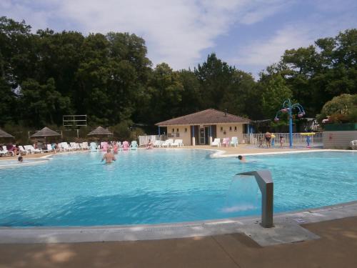 une grande piscine avec des gens dans l'eau dans l'établissement Mobilhome 3 chambres tout confort, proche de la plage, à Saint-Brévin-les-Pins