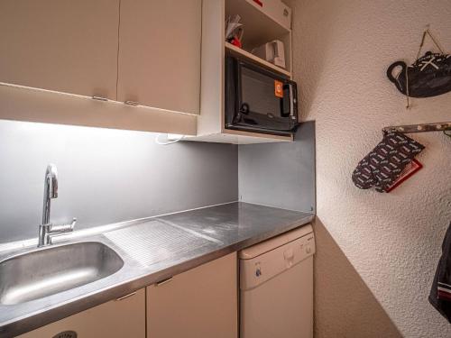 une petite cuisine avec un évier et un micro-ondes dans l'établissement Valmorel - Appartement 2 pièces avec balcon, accès pistes et animaux admis - FR-1-356-494, à Valmorel
