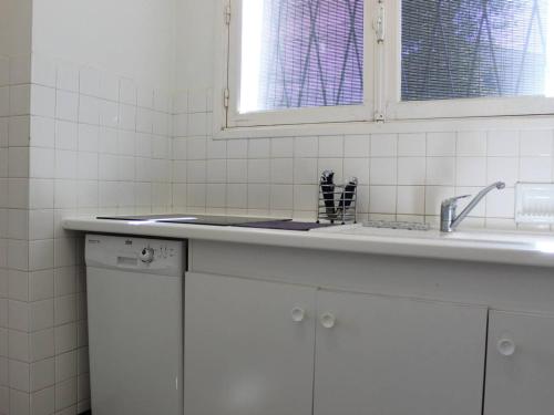 une cuisine blanche avec un évier et une fenêtre dans l'établissement Maison 4 pièces proche plage, Saint-Trojan-les-Bains - FR-1-246A-362, à Saint-Trojan-les-Bains