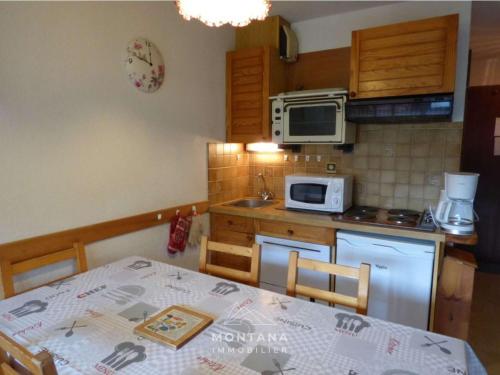 une petite cuisine avec une table et un micro-ondes dans l'établissement Appartement confortable avec balcon pour 6 personnes - FR-1-458-231, au Grand-Bornand