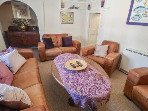 a living room with couches and a table and chairs at The Plover in Holt