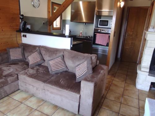un salon avec un canapé et une cuisine dans l'établissement Chalet montagnard confortable à Super Besse avec grand terrain et parking privé - FR-1-814-139, à Besse-et-Saint-Anastaise