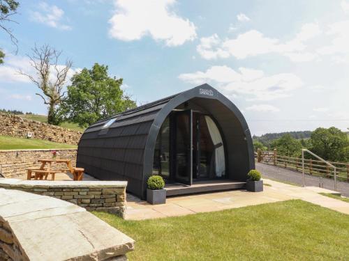 a black igloo house in a yard with grass at Barley in Nelson