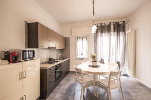 Una cocina con una mesa y sillas en una cocina. en Appartamento Leone, en Misano Adriatico