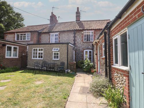 an external view of a brick house with a yard at Pebble in Holt