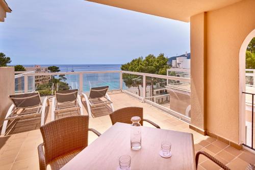 a balcony with a table and chairs and the ocean at Universal Aparthotel Don Camilo in Sant Elm