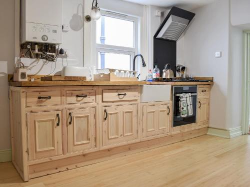 a kitchen with a large wooden island with a stove at Brook Cottage in Dawlish