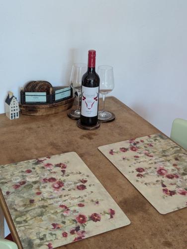a bottle of wine sitting on a table with two glasses at Kuhstall Sinzenich in Zülpich