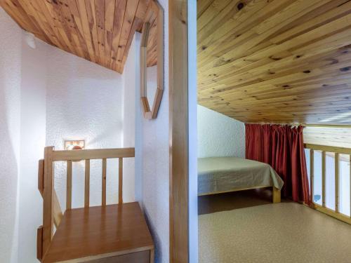 Cette petite chambre comprend un lit et un plafond en bois. dans l'établissement Duplex rénové skis aux pieds, animaux admis à Valmorel - FR-1-356-294, à Valmorel