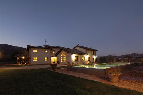 a house with a swimming pool in front of a house at Vocabolo Monache in Ponte Pattoli